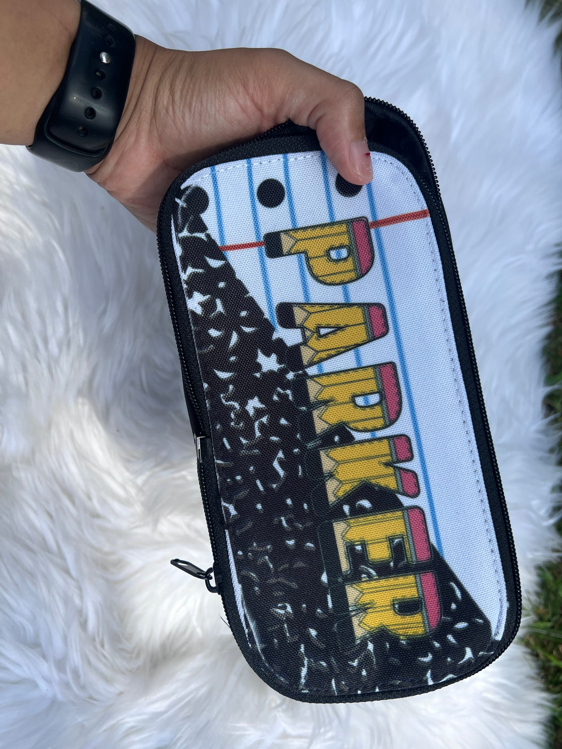 Pouch with 'PARKER' printed on it held by a hand against a white fluffy background
